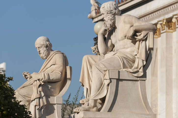 Classical statues of Plato and Socrates.
