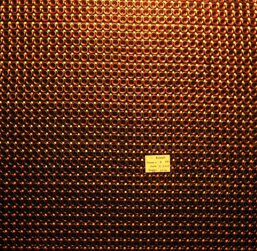 Bottles of Ruinart Champagne aging in a cellar in Reims