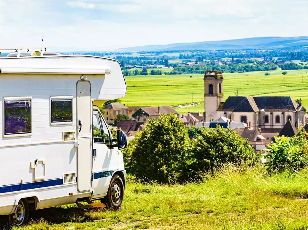 A campervan parked by Pommard village with a view of the church