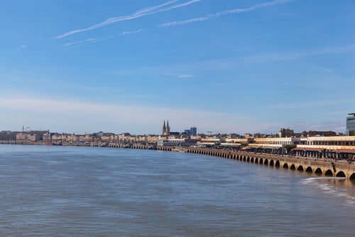 A view of a river and a row of buildings along the quai des chartrons in central Bordeaux