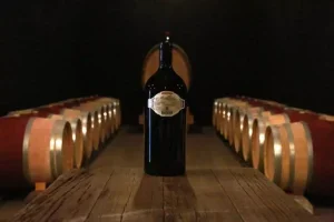 A bottle of Cathiard wine surrounded by barrels in a cellar
