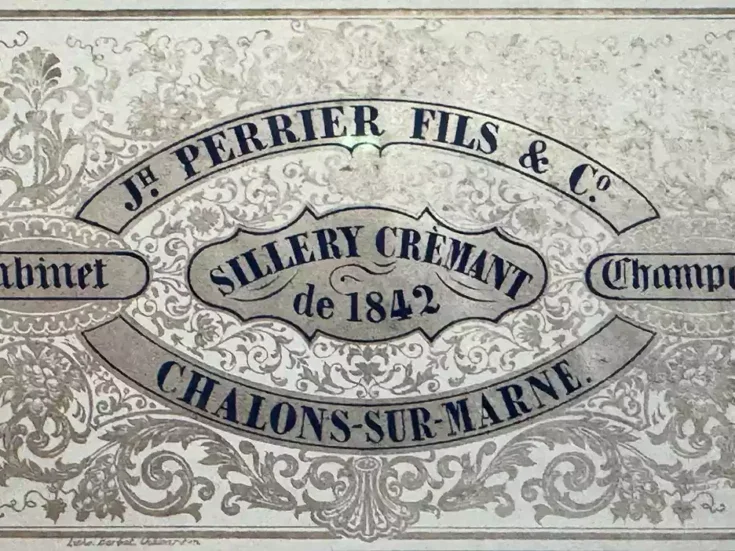 An old Joseph Perrier label with black letters on shiny silver patterned paper