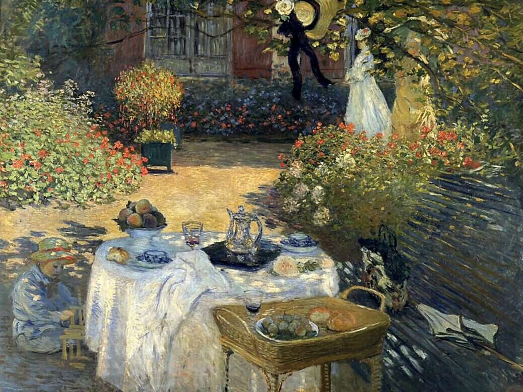 An impressionist painting of a table with white tablecloth laid with food and jugs of water and wine in dappled sunlight in a pretty garden with a child sitting on the floor by the table and a man and two women standing in the background in front of a window