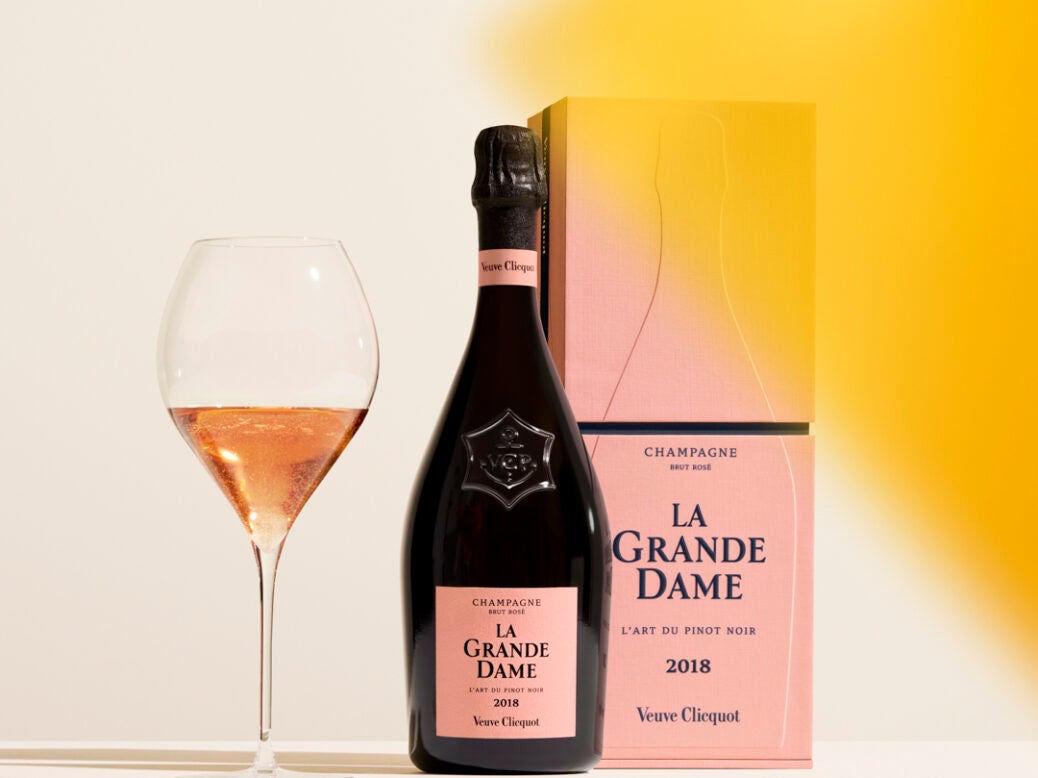 A bottle and a box of 2018 veuve clicquot La Grande Dame Rosé with a glass in which a little has been poured and a yellow colour swatch to the side.