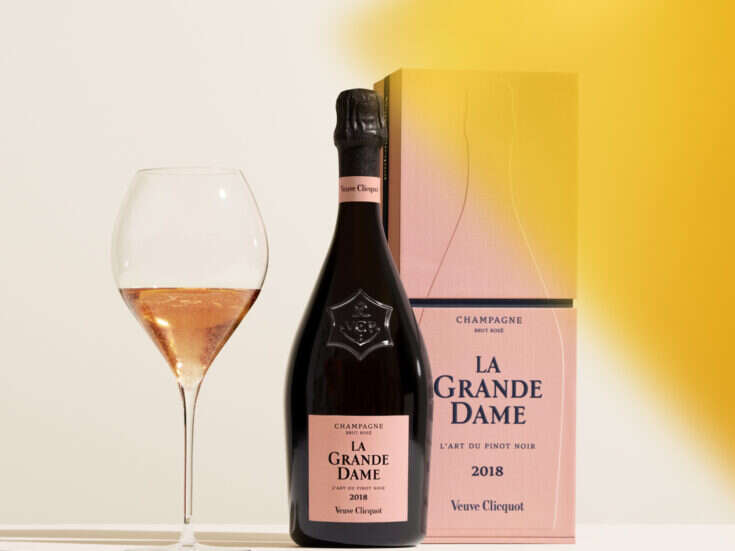 A bottle and a box of 2018 veuve clicquot La Grande Dame Rosé with a glass in which a little has been poured and a yellow colour swatch to the side.