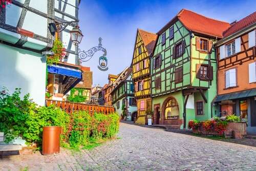Very brightly painted and wooden-gabled houses in the streets of Riquewihr on a sunny day