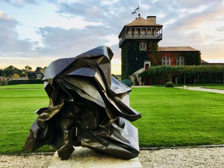 a metal sculpture by an immaculate lawn in front of Château Smith Haut Lafitte